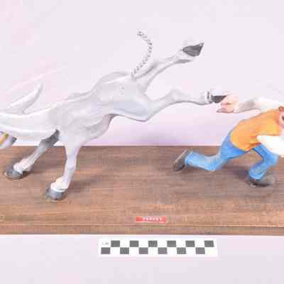 Painted wood carving of mule and man