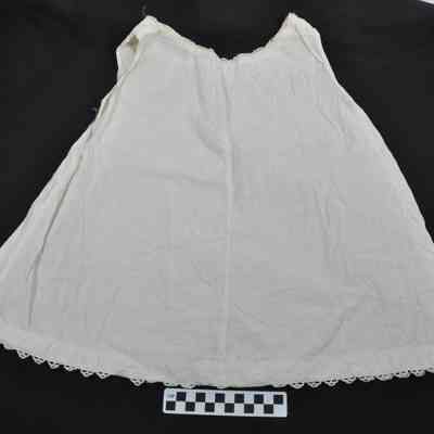 White child's slip with lace decoration around collar and hem