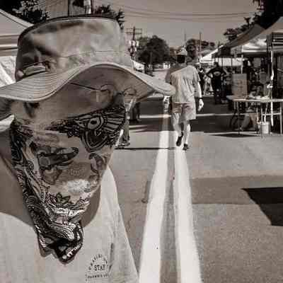 Individual wearing mask at Charles Town Farmers Market; vendor stands (IMG3914007)