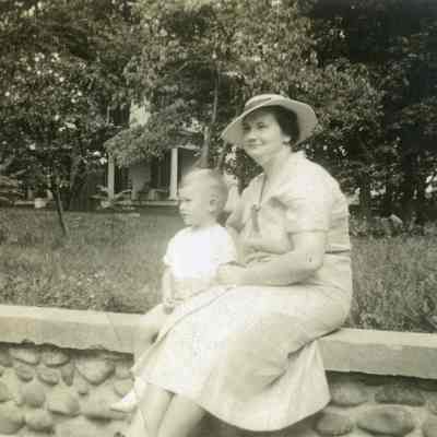 Bobby Orndorff and his mother sitting on a stone wall