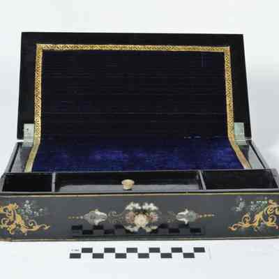 A drawer from multi-drawered,rectangular papier mache sewing cabinet