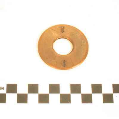 Round piece of brass with a hole in it