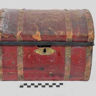 Wood trunk covered with thin red leather or leatherette