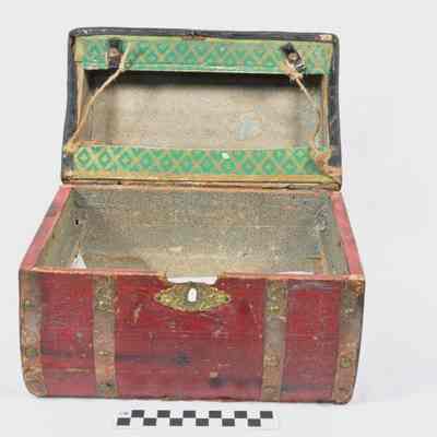 Wood trunk covered with thin red leather or leatherette