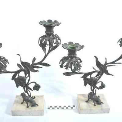 Two cast iron, brass, bronze and marble candlesticks