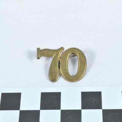 Stamped brass hat insignia "70"