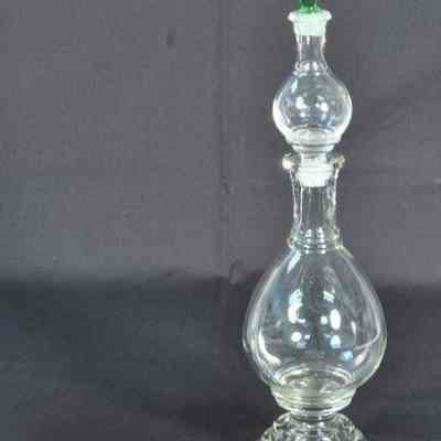 Clear glass apothecary bottle with light green stopper in top