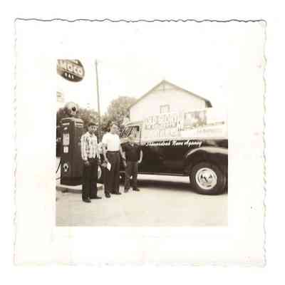 Three unidentified males at Welsh's Grocery (Bakerton Store) with store of Jap Manuel in the background. They are posing near a Shenandoah News Agency truck and a gas pump: IMG2025.026.001 (6)