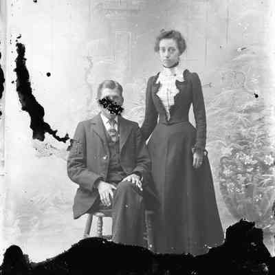 Unidentified woman standing and man sitting
