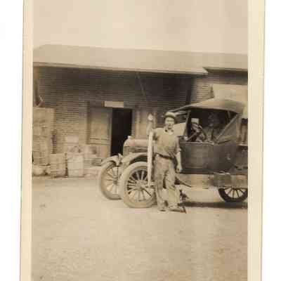 Martin D. Welsh, Sr. holding prized eel caught in the Potomac in front of Preston Millard's "company" store with a cat at his feet, Bakerton, WV, undated: IMG2025.026.001 (12)