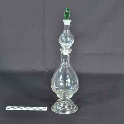 Clear glass apothecary bottle with light green stopper in top