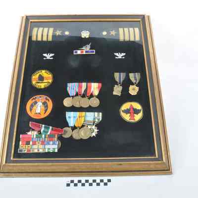 Framed collection of U. S. Navy insignia, medals and patches