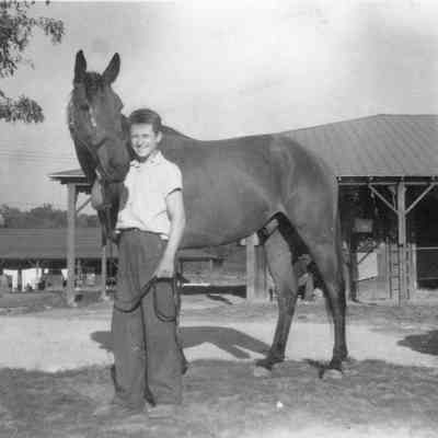 Unidentified race track workers, stables, and horses