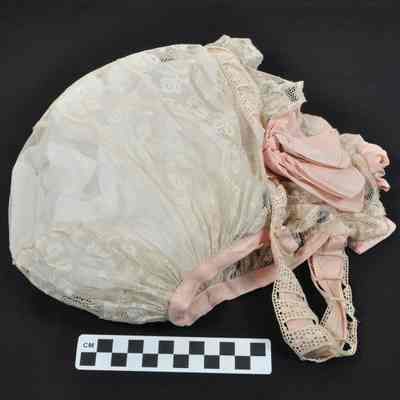 Lace cap with pink ribbon around edges