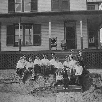 Merchant family and unidentified young women sitting on ground and steps (IMG3900003)