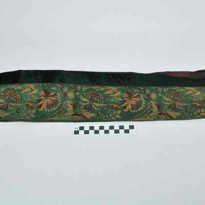 Dark green material with dark red and gold flower designs