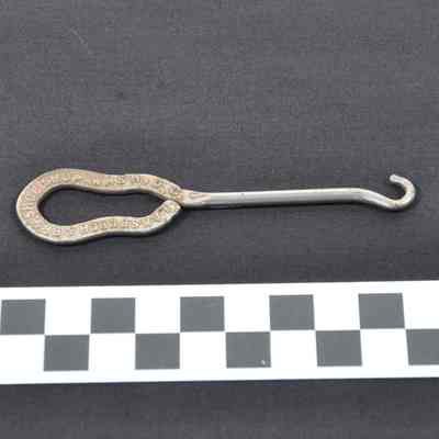 Metal (silver-colored) buttonhook with flat, open handle