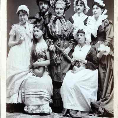 Six women and one man posing as Mrs. Jarley's Waxworks