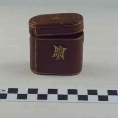 Oblong brown leather cover, glass bottle inside