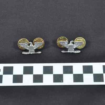 Set of eagle pins worn on a U.S. Navy khaki uniform