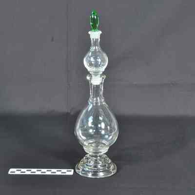 Clear glass apothecary bottle with light green stopper in top