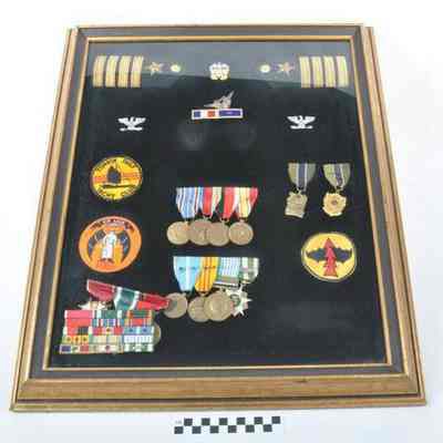 Framed collection of U. S. Navy insignia, medals and patches