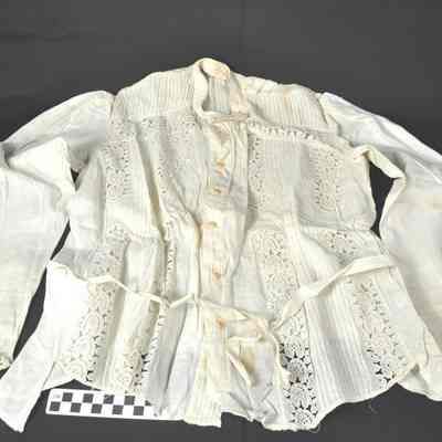 White blouse with embroidered design on front with holes
