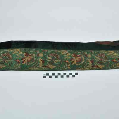 Dark green material with dark red and gold flower designs