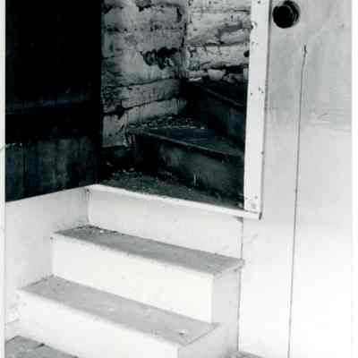 Close-up view of interior stairs of farmhouse showing open doorway