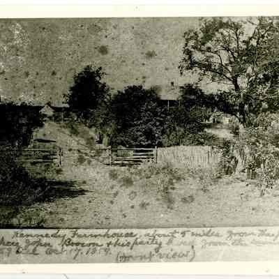 Photograph of exterior of farmhouse showing wooden fence