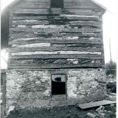 Exterior side of farmhouse showing exposed wood and stone