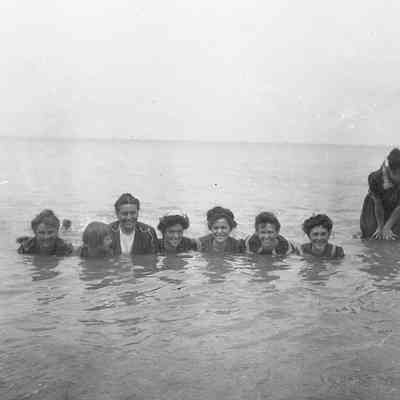 2021.12.310f: A group of happy people is swimming together in the sea.