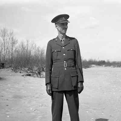 2021.12.310h: A man in a military uniform stands on a beach.