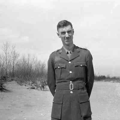 2021.12.310i: A man in a military uniform stands on a beach.