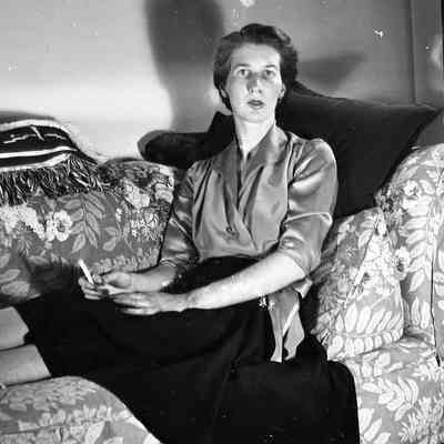 2021.12.310j: Dorothy Burnham sits on a couch looking at the camera.