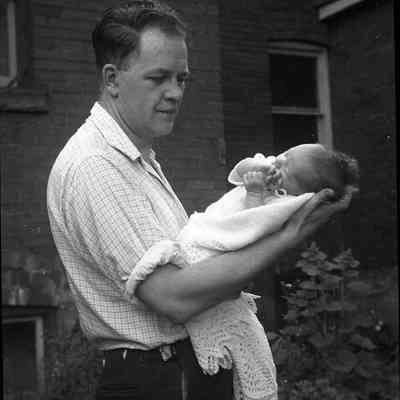 2021.12.301m: Photo of Harold Burnham holding a baby. Photo taken circa 1955.