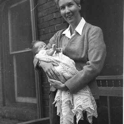 2021.12.310n: Photo of Dorothy Burnham holding a baby. Photo taken circa 1955.