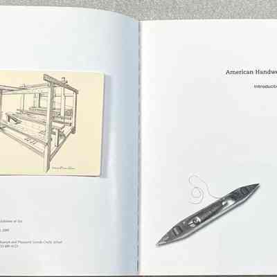 American Handweaving Museum: Introduction to the Collection - Inside Cover: Open book showing a handloom illustration on an attached card, and text on the left page. Right page has the title "American Handweaving Museum: Introduction to the Collection" and a weaving shuttle image.