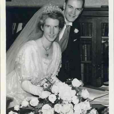 Photo - 2021.12.289d: Dorothy and Harold Burnham pose, surrounded by florals. Written on the back, "Signing the Register, In the Vestry".
