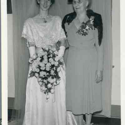 Photo - 2021.12.289e: Dorothy Burnham in her wedding dress, posing with older woman (unidentified). Likely Jessie MacDonald (nee Dennistoun), Dorothy's mother.