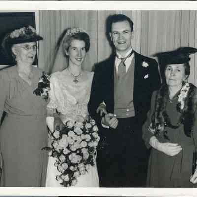 Photo - 2021.12.289h: Dorothy and Harold Burnham in their wedding attire, posing with two women (unidentified). Likely Jessie MacDonald (nee Dennistoun) on left and Florence Mary Burnham (nee Manson) on right, the couples mothers.