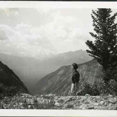 Photograph of Dorothy - 2021.12.291b: The same photo of Dorothy (as 2021.12.291a) at Sunshine Valley - The Simpson Pass. Photo is attached to black construction paper with two holes punched in it. (Likely part of a scrapbook at one point)