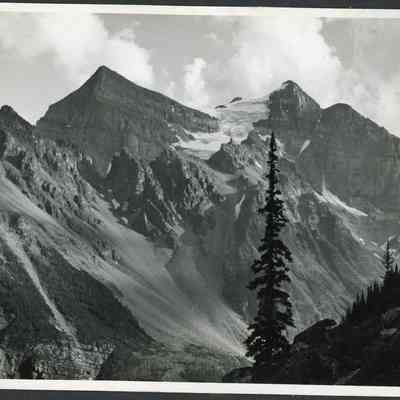 Photograph of Mountains - 2021.12.291h: Taken at Sunshine Valley - The Simpson Pass in August 1942. Photo is attached to black construction paper with two holes punched in it. (Likely part of a scrapbook at one point).
