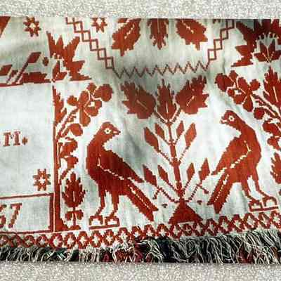 Photo 2: Photo of a Coverlet belonging to Margo Smith. In bottom left corner of the photo, initials J.M. and the year 1857 stitched into the coverlet.
