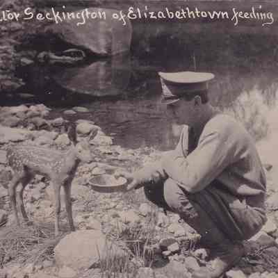 Game Protector Seckington of Elizabethtown Feeding Fawn
