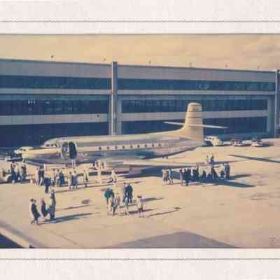 Photograph in a cardboard display folder of Jetliner on tarmac.