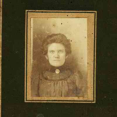 Unidentified Woman with Dark Dress and a Large Pin at her Neck.