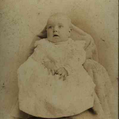 Unidentified Baby in White laying on a Blanket