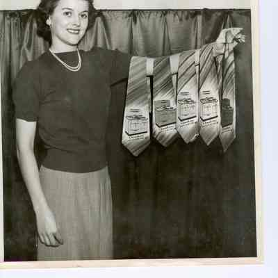 Adult female, unidentified, holding five neckties with advertising for Chambers Ranges.