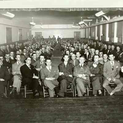Group business men, seated, in a large room